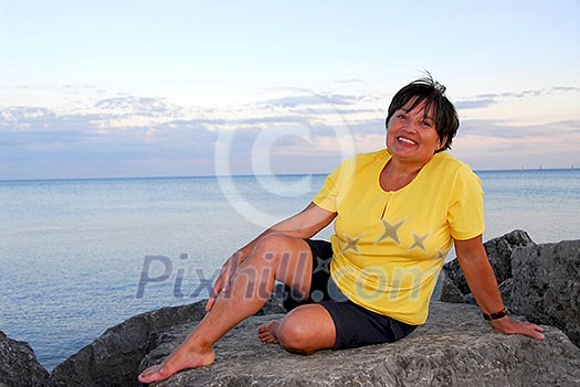 Mature woman relaxing on a shore Mature woman relaxing on a shore
