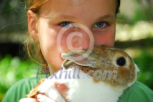 Portrait of a young girl holding a bunny outside Portrait of a young girl holding a bunny outside