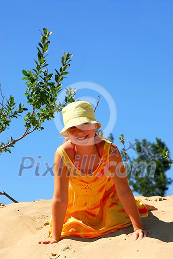 Young girl sitting on top of a sand dune Young girl sitting on top of a sand dune