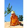 Young girl sitting on top of a sand dune