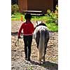 Young girl leading her pony back to the stable