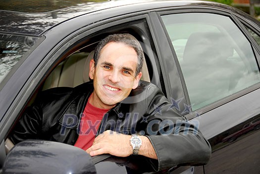 Smiling man looking from a car window