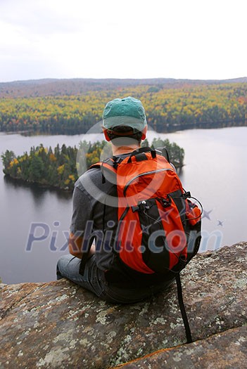 Man on top of a hill enjoying a scenic view Man on top of a hill enjoying a scenic view
