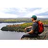 A hiker sitting on a cliff edge enjoying scenic view