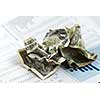 Crumpled US dollars on financial chart report
