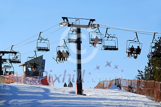 Chairlift with skiers on downhill ski resort Chairlift with skiers on downhill ski resort