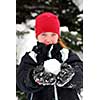 Young girl holding a snowball in her hands