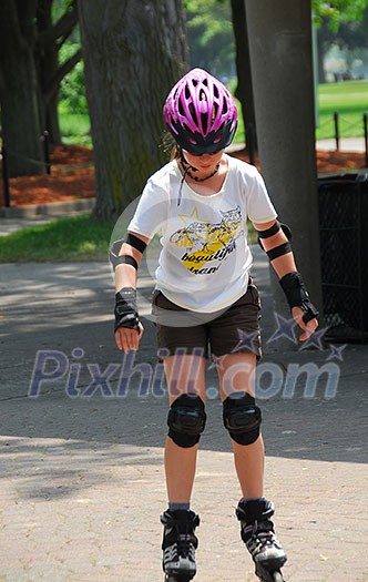 Young girl rollerblading in a summer park