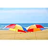 Two beach ubrella standing on ocean shore