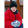Portrait of a boy making a snowball in winter park