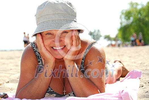 Mature woman lying on a sandy beach Mature woman lying on a sandy beach