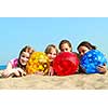 Portrait of four young girls with colorful beach balls