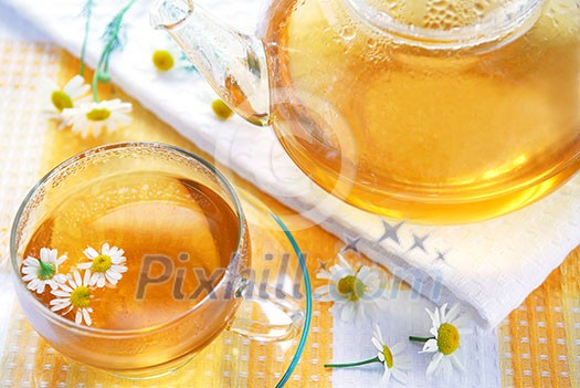 Teacup and teapot with soothing chamomile tea Teacup and teapot with soothing chamomile tea