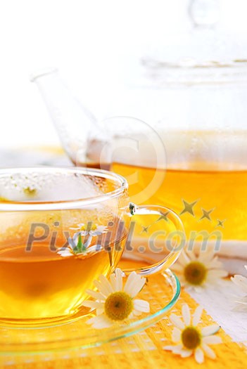 A teacup and a teapot with soothing herbal camomile tea