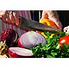 Hands of an elderly woman cutting fresh vegetables