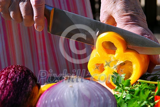 Hands of an elderly woman cutting fresh vegetables Hands of an elderly woman cutting fresh vegetables