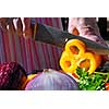 Hands of an elderly woman cutting fresh vegetables