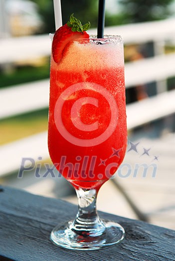 Cold strawberry daiquiri beverage served on an outdoor patio