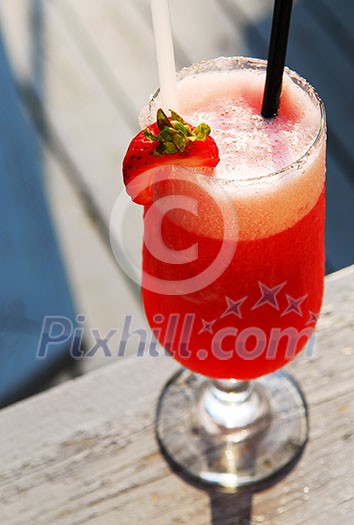 Cold strawberry daiquiri beverage served on an outdoor patio