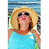 Teenage girl wearing a straw hat relaxing on a beach