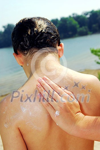 Children helping each other to apply sunscreen on a beach Children helping each other to apply sunscreen on a beach