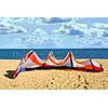 Big kite for kite surfing lying on a sandy beach