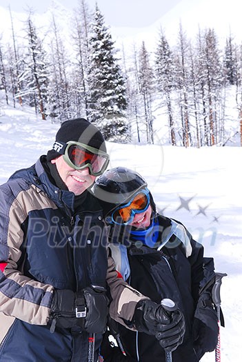 Father and daughter enjoying downhill skiing in winter mountains