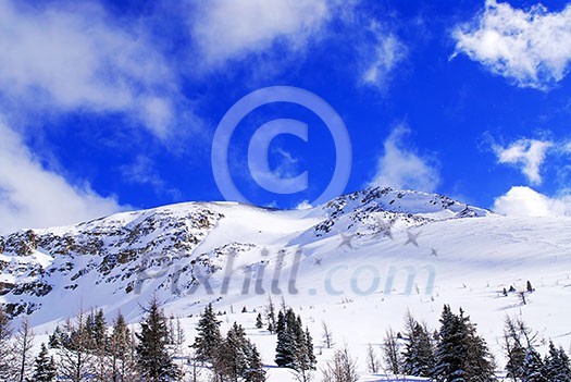 Snow covered mountain tops in Canadian Rockies with bright blue sky and snowflakes Snow covered mountain tops in Canadian Rockies with bright blue sky and snowflakes