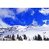 Snow covered mountain tops in Canadian Rockies with bright blue sky and snowflakes