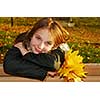 Portrait of a beautiful teenage girl with yellow fall maple leaves