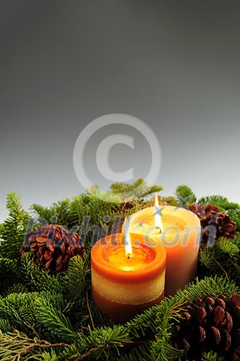 Christmas arrangement of burning candles and green spruce branches, background