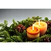 Christmas arrangement of burning candles and green spruce branches, background