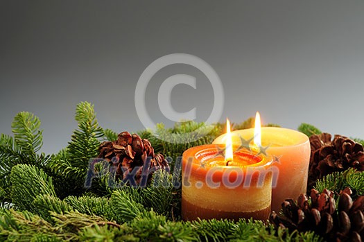 Christmas arrangement of burning candles and green spruce branches, background