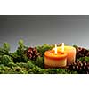 Christmas arrangement of burning candles and green spruce branches, background