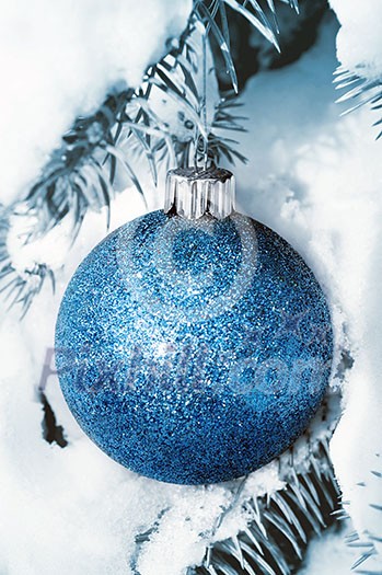 Christmas decoration hanging on snow covered spruce tree outside