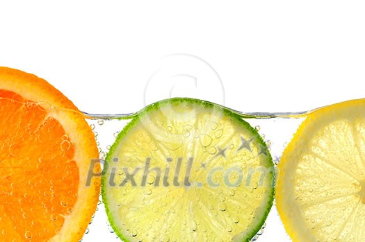 Orange lemon and lime slices in water with air bubbles on white background Orange lemon and lime slices in water with air bubbles on white background