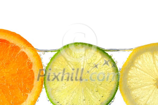 Orange lemon and lime slices in water with air bubbles on white background