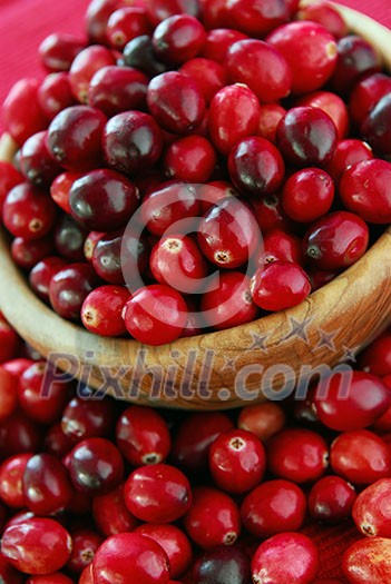 Fresh red cranberries in a wooden bowl Fresh red cranberries in a wooden bowl