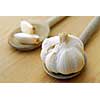 Bulbs and cloves of garlic on wooden cooking spoons