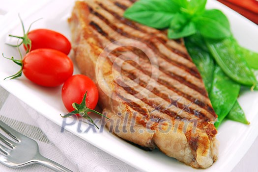 Grilled New York steak served on a plate with vegetables
