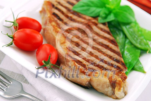 Grilled New York steak served on a plate with vegetables Grilled New York steak served on a plate with vegetables