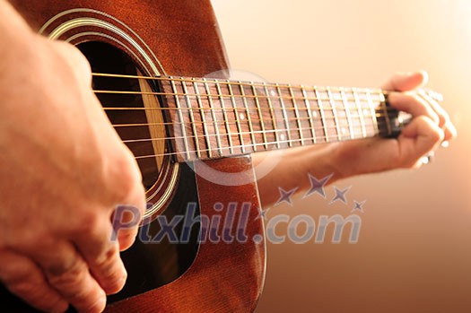 Hands of a person playing an acoustic guitar Hands of a person playing an acoustic guitar