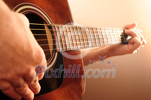 Hands of a person playing an acoustic guitar