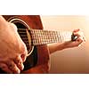 Hands of a person playing an acoustic guitar