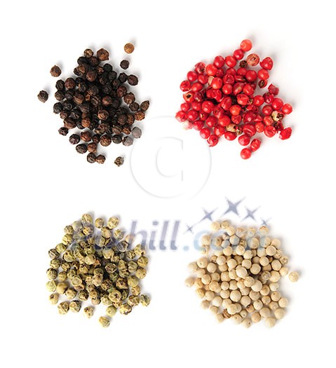 Heaps of assorted peppercorns on white background, top view