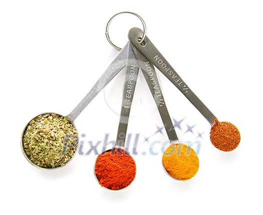 Assorted spices in measuring spoons on white background