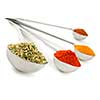 Assorted spices in metal measuring spoons on white background