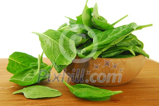 Fresh spinach iin a wooden bowl on a cutting board Fresh spinach iin a wooden bowl on a cutting board
