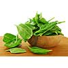 Fresh spinach iin a wooden bowl on a cutting board