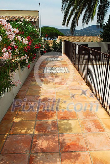 Courtyard of mediterranean villa in French Riviera with ceramic tile walkway Courtyard of mediterranean villa in French Riviera with ceramic tile walkway